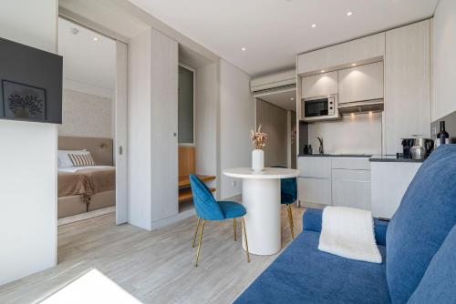 a living room with a blue chair and a kitchen at Smartr Porto Gaia in Vila Nova de Gaia