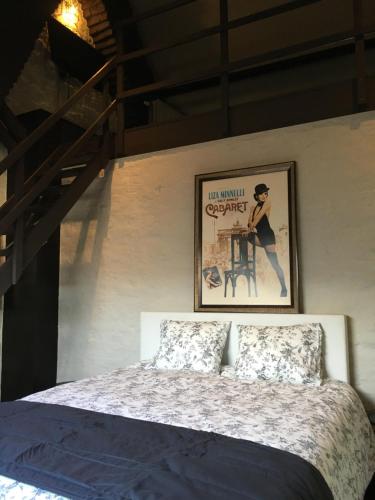 
a room with a bed and a painting on the wall at B&B Le Grand Cabaret in Nieuwpoort
