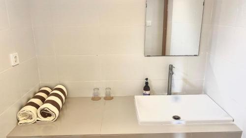 a white bathroom with a sink and a mirror at Casa Komala Uluwatu in Uluwatu