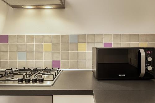 a microwave oven sitting next to a stove top at Like at Home Trastevere in Rome