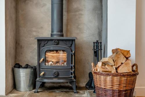 a stove in a room with a basket of wood at Bogan in Coldingham