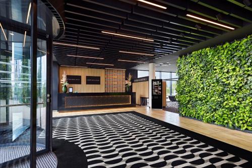 a lobby with a green wall in a building at LÉGÈRE HOTEL Erfurt in Erfurt