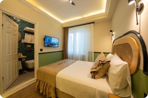 a hotel room with a bed and a bathroom at Hotel Zon in Serdivan