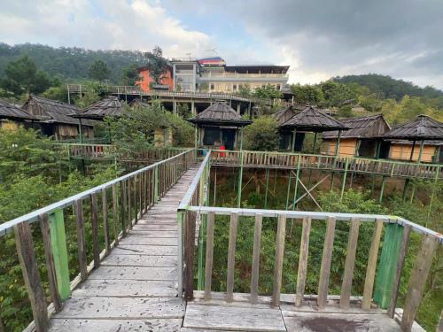 a bridge over a river with a group of houses at Homestay duy mạnh gần suối nước khoáng nóng trạm tấu in Cham Ta Lao
