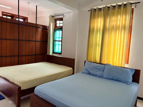 a bedroom with two beds and a window at Metro Stay in Kurunegala