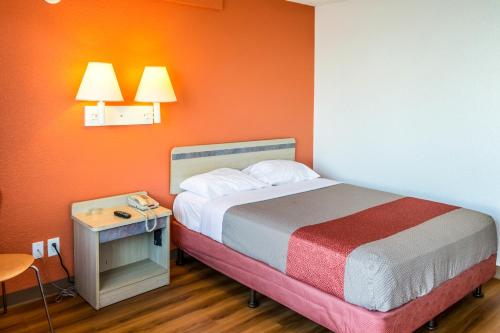 a bedroom with a bed and a table with a phone at Bakersfield - Motel in Bakersfield
