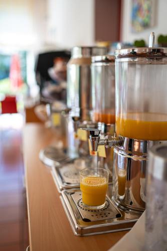 a coffee maker with a tray of orange juice at Parkhotel Emmaus - Casa del Sole in Ascona