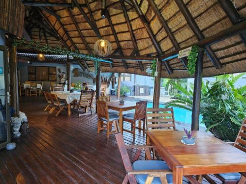 a dining room with tables and chairs on a wooden deck at Leopard Corner Lodge in St Lucia