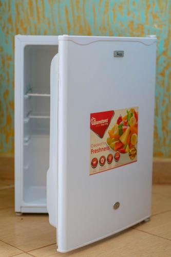a white refrigerator with a box of cereal on the door at Hotel Quill in Busia