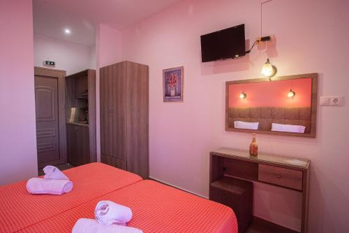 a small room with two beds and a mirror at Studios Nopi-Zoi in Skiathos Town