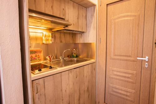 a kitchen with a sink next to a door at Studios Nopi-Zoi in Skiathos Town