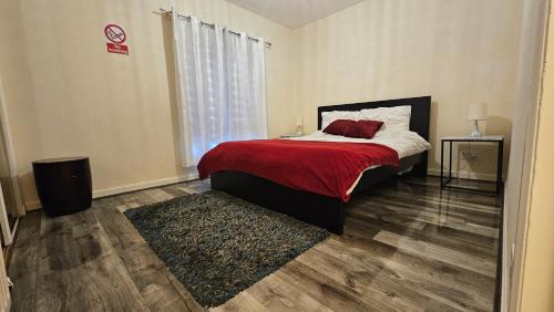 a bedroom with a bed with a red blanket at Charlotte Apartment in Aberdeen