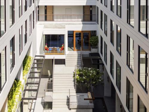 an aerial view of a building with a stairway between two buildings at Novotel Chiangmai Nimman Journeyhub in Chiang Mai
