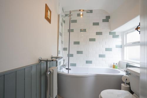 ein Badezimmer mit Badewanne, Toilette und Waschbecken in der Unterkunft Cosy Cottage in Youlgreave