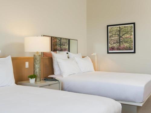 two beds in a hotel room with white pillows at 21c Museum Hotel Bentonville - MGallery in Bentonville