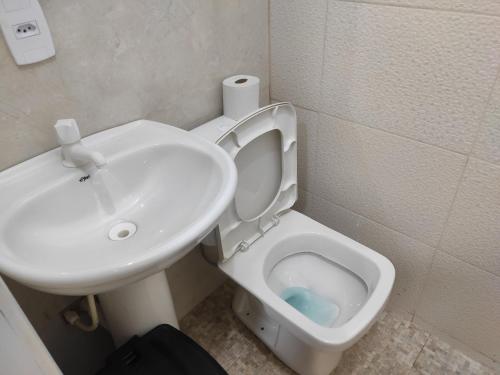 a bathroom with a white toilet and a sink at Apartamento Nami 2 in Cacoal