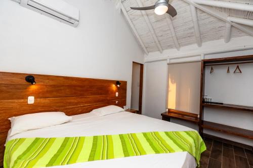 a bedroom with a large bed with a wooden headboard at Hoja de Palma Bungalows in Canoas De Punta Sal