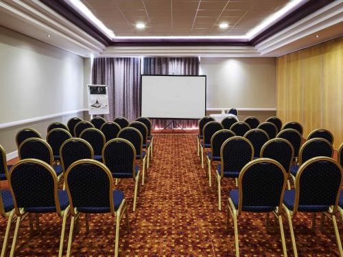 a conference room with chairs and a white screen at Mercure St Helens in Saint Helens