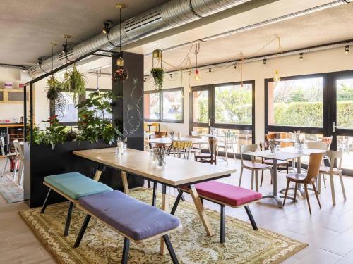a restaurant with tables and chairs and windows at greet Hotel Beaune in Beaune