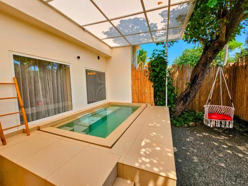 a swimming pool in the backyard of a house at ETHER Marari Beachfront in Mararikulam