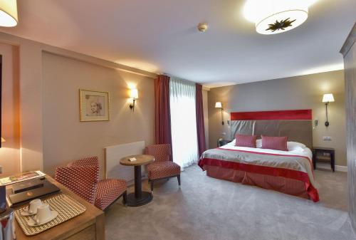a hotel room with a bed and some chairs at Hôtel Golf Château de Chailly in Chailly-sur-Armançon