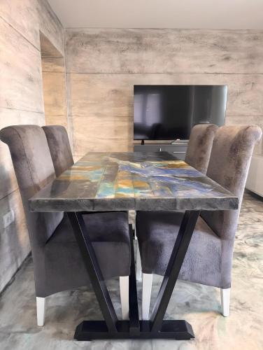 a dining room table with chairs and a television at Avala Villa With Indoor Pool & Spa in Vrčin