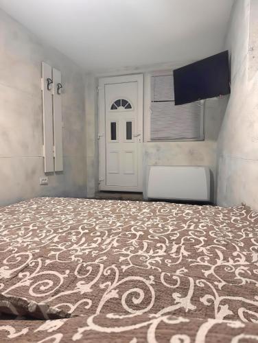 a bedroom with a large bed and a white door at Avala Villa With Indoor Pool & Spa in Vrčin