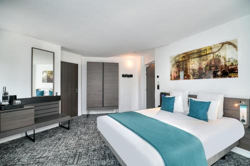 a bedroom with a large white bed with blue pillows at Novotel Paris Centre Bercy in Paris