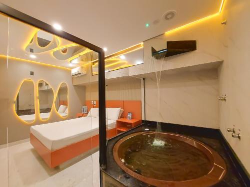 a bedroom with a bed and a tub in a room at Motel Gaia Radial Leste in Sao Paulo