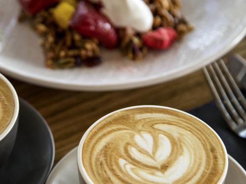 a cup of coffee on a table with a plate of food at Mercure Marseille Canebière Vieux-Port in Marseille