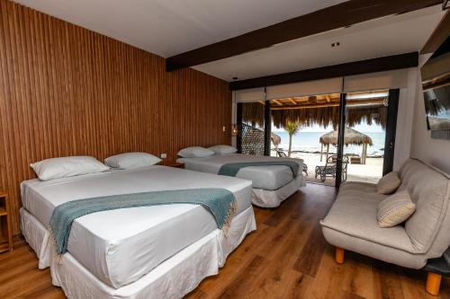 a bedroom with two beds and a couch and a patio at Hoja de Palma Bungalows in Canoas De Punta Sal