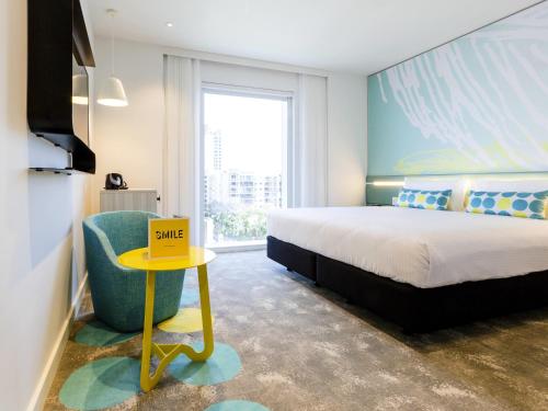 a bedroom with a bed and a chair and a tv at ibis Styles East Perth in Perth