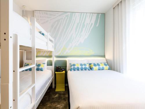 a bedroom with two bunk beds and a mural at ibis Styles East Perth in Perth