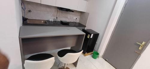 cocina con 2 sillas blancas y lavamanos en Business Stay, en Māripat