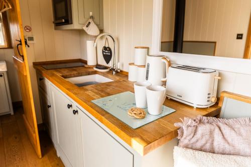 a kitchen counter with a toaster and a cookie on it at Cherry Blossom Hut in Bristol