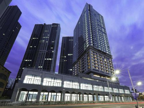 a tall building with three tall buildings in a city at Mercure Ambassador Ulsan in Ulsan