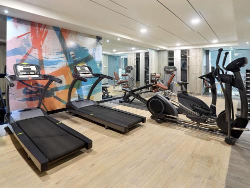 a gym with several treadmills and elliptical machines at Novotel Suites Yogyakarta Malioboro in Yogyakarta