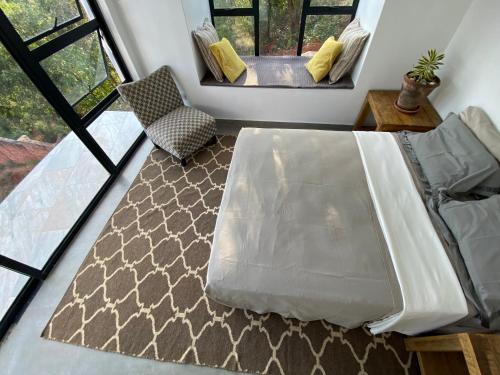 a bedroom with a bed and a couch and windows at Hayhill Treetop Escape in Harare