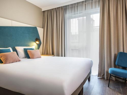 a hotel room with a large bed and a window at Aparthotel Adagio Lille Centre Grand Place in Lille