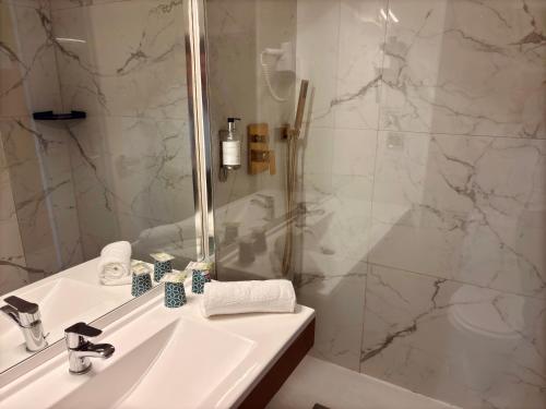 a bathroom with a sink and a shower at Kyriad Direct Arpajon in Arpajon