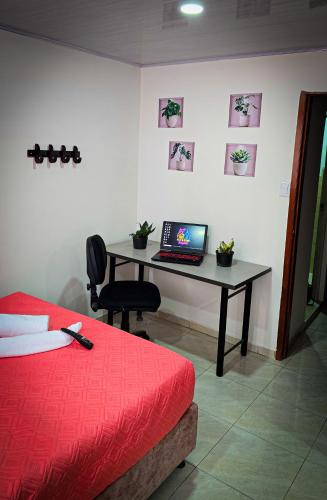 a bedroom with a desk with a laptop on it at Fly N' Stay Bogota in Bogotá