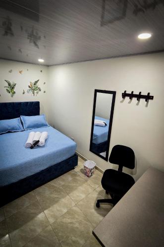 a bedroom with a bed and a mirror and a chair at Fly N' Stay Bogota in Bogotá
