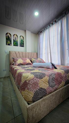 a bed with a quilt on it in a bedroom at Fly N' Stay Bogota in Bogotá