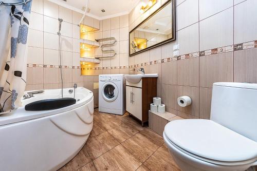 a bathroom with a toilet sink and a washing machine at Уютная квартира с джакузи в центре Киева in Kyiv