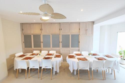 a dining room with white tables and white chairs at Augusta 7 in Salta