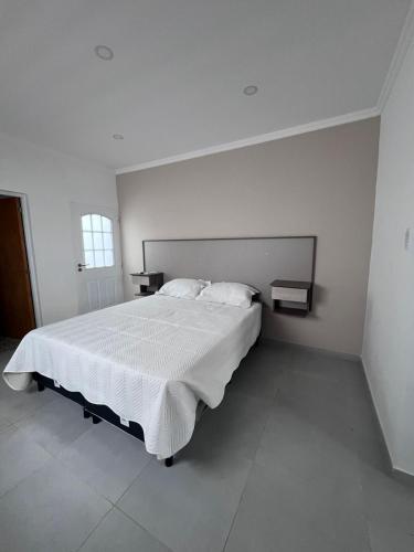 a white bedroom with a large bed with white sheets at Alojamiento Madariaga 224 in Goya