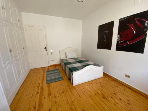 a bedroom with a bed in a room with wooden floors at Villa Maadi 35 -R302- Double Room in Cairo