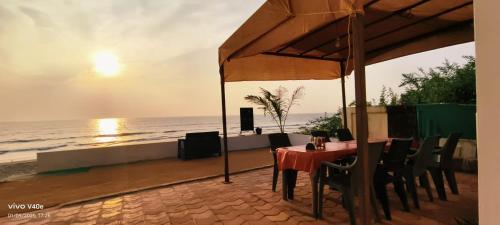 een tafel met stoelen en een parasol op het strand bij WHITE SEASONS RESORT AND SPA DEVBAG in Chaoka