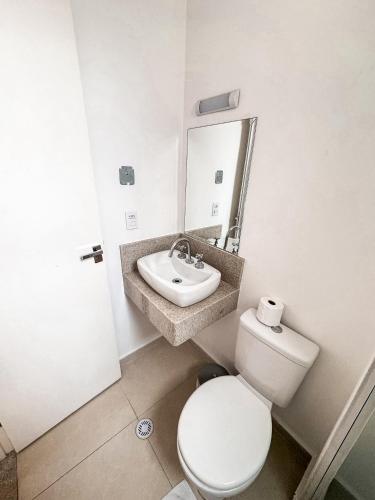 a bathroom with a white toilet and a sink at Hotel Pigalle, próximo a Expo São Paulo in Sao Paulo