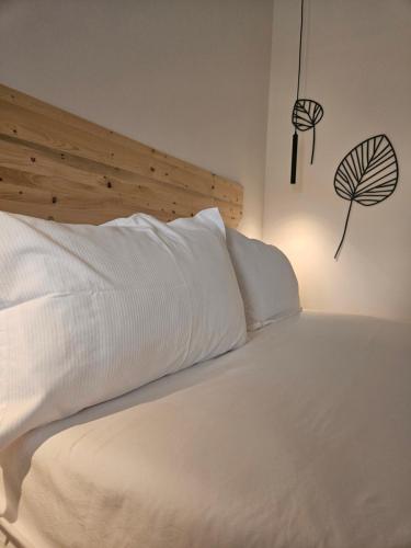 a white bed with white sheets and a wooden headboard at Dolcevita guest house in Torreano